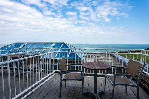 a balcony with two chairs and a table and the ocean at Botany Bay Hotel in Broadstairs