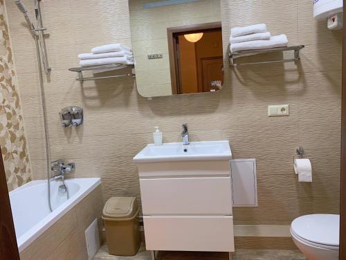 La salle de bains est pourvue d'un lavabo, de toilettes et d'un miroir. dans l'établissement Апартаменти-студія на Герцена, à Tchernivtsi