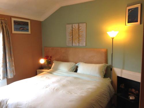 a bedroom with a large bed with white sheets at The Old Station House in Matlock