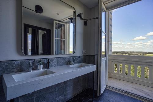 a bathroom with two sinks and a large window at Le Château des Forges in Angers