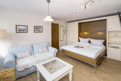 a living room with a bed and a couch at Strandläufernest in Tinnum