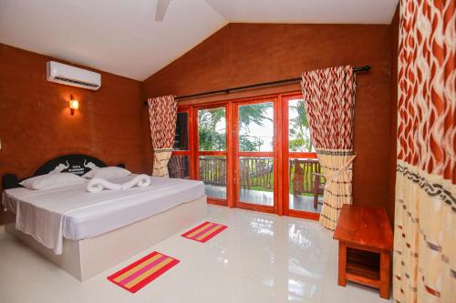 a bedroom with a bed and a large window at Yala Elephant Cottage in Tissamaharama