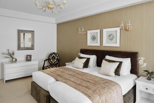 a bedroom with a large bed and a chandelier at Arlington House Apartments in London