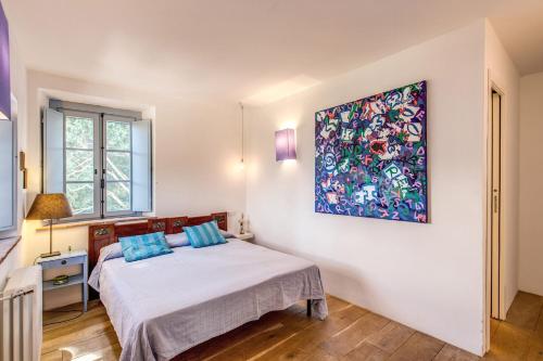 a bedroom with a bed and a painting on the wall at Villa Benedetta - Homelike Villas in Osimo