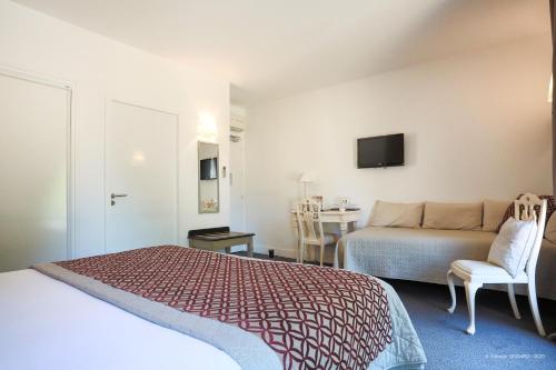 a hotel room with a bed and a table at Hotel Restaurant du Parc en Bord de Rivière in Fontaine-de-Vaucluse