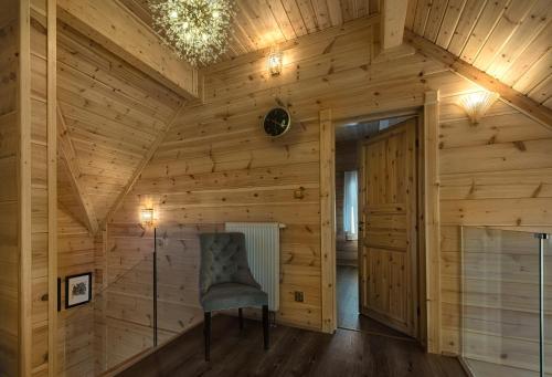 a room with a chair in a wooden wall at Rezidencia Woodchalet in Veľká Lomnica