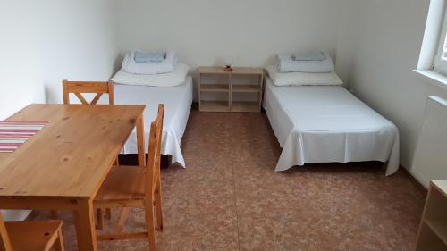 een kamer met 2 bedden, een bureau en een tafel bij Ubytovna Koupaliště in Litoměřice