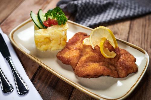a plate of food with chicken and vegetables on a table at DER SCHWAN Hotel & Restaurant in Schwanstetten