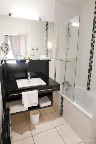 a bathroom with a sink and a shower at Hotel Restaurant du Parc en Bord de Rivière in Fontaine-de-Vaucluse