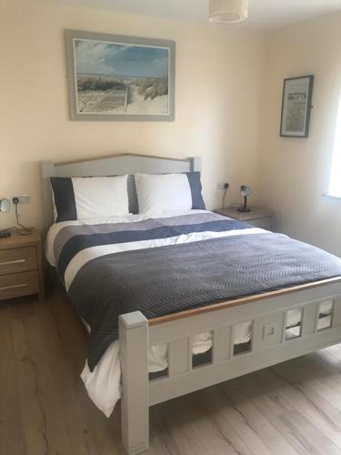 a bedroom with a large bed with blue and white sheets at The Stable Self Catering Cottage @ Cappa House BnB in Eyeries