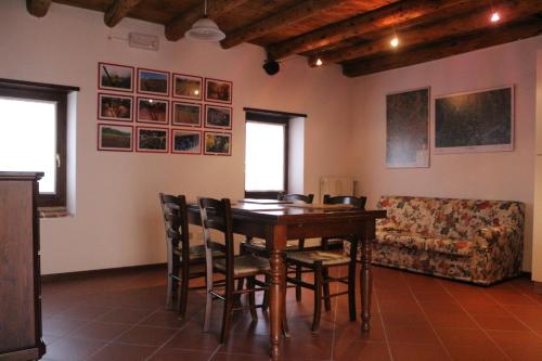 ein Esszimmer mit einem Tisch, Stühlen und einem Sofa in der Unterkunft Corte Spinosa in Negrar