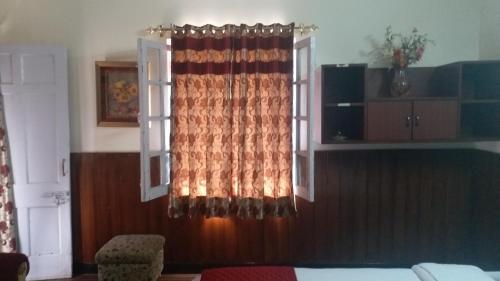 a bedroom with a window with a curtain at Rosewood Estate in Chail