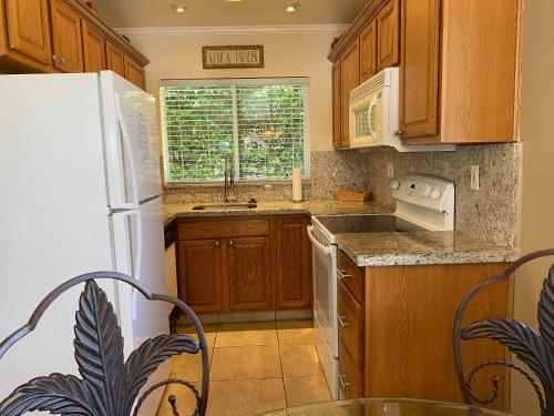 a kitchen with wooden cabinets and a white refrigerator at Casitas Coral Ridge in Fort Lauderdale