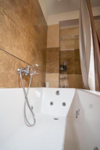 a bathroom with a white tub and a shower at Meteora 360 Apartment by Meteora Residencies in Kalabaka