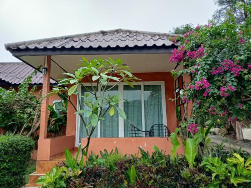 a house with a window and some plants and flowers at ภูเรือวิว รีสอร์ท in Loei