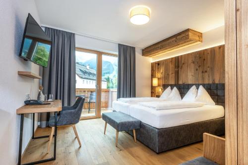 Habitación de hotel con cama y escritorio en Hotel Goldener Stern, en Abtenau