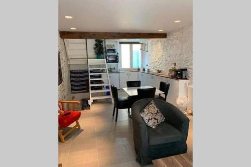 un salon avec une table et des chaises et une cuisine dans l'établissement Havre de paix au pied de la montagne, à Les Ilhes