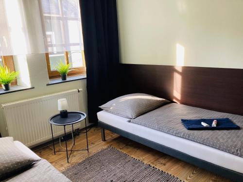 a small bedroom with a bed and a table at Pension Boulevard in Waldsassen