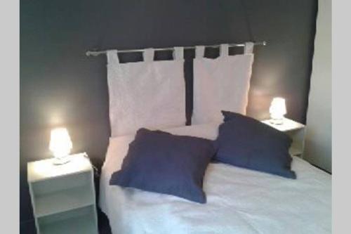 a bedroom with a bed with two night stands and two lights at GITE à LA FERME PRES VULCANIA-GR89 in La Goutelle