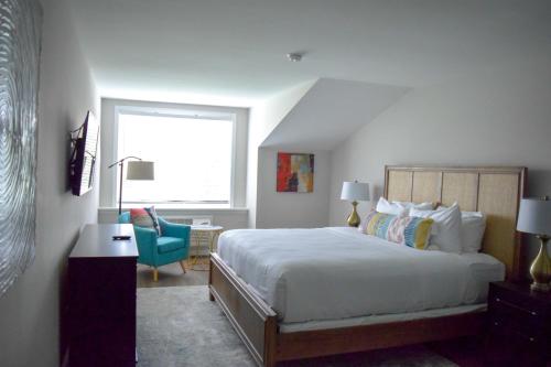 a bedroom with a bed and a desk and a window at Tilghman Island Inn in Tilghman Island