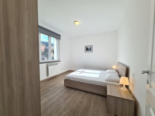a white bedroom with a bed and a window at Santa Caterina in Levanto