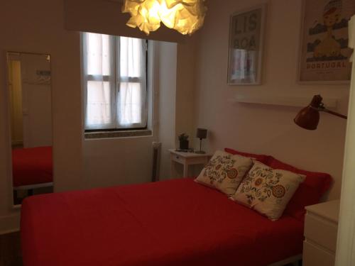 a bedroom with a red bed with two pillows at Mouraria 1 - Descubra a Lisboa Medieval in Lisbon