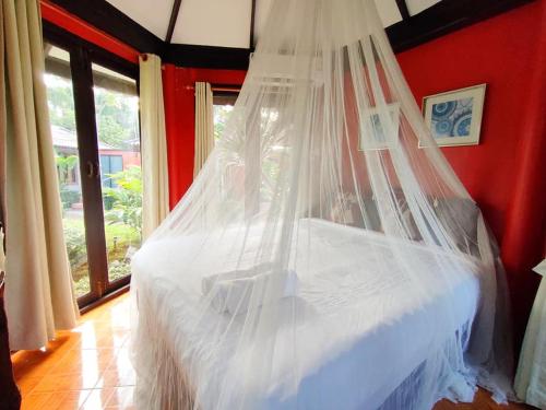 a bedroom with a bed with a mosquito net at ภูเรือวิว รีสอร์ท in Loei