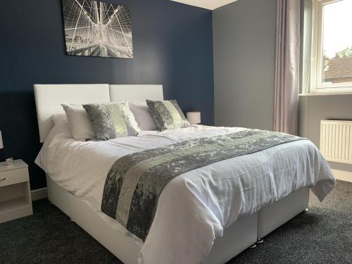 una camera da letto con un grande letto bianco con cuscini di Toothbrush Apartments - Central Ipswich - Nr Train Station a Ipswich