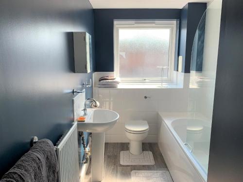 a bathroom with a sink and a toilet and a window at Toothbrush Apartments - Central Ipswich - Nr Train Station in Ipswich