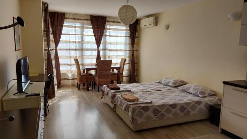 a bedroom with a bed and a table and a television at Panorama Apartment & Rooms Veliko Turnovo in Veliko Tŭrnovo