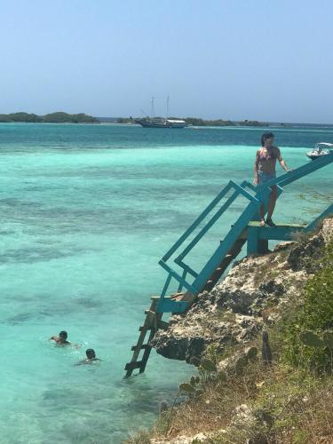 a man standing on a stairs in the water at Beachfront Bella Horizonte 4 in Savaneta