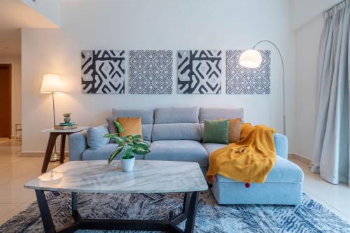 a living room with a blue couch and a table at GuestReady - Panoramic View of Dubai Skyline in Dubai