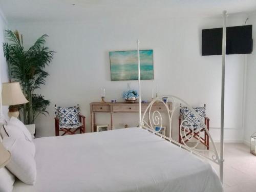 um quarto com uma cama branca e uma secretária em Ocean Front Property - Villa 4 Aruba w pool view em Savaneta