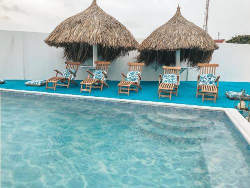 un grupo de sillas y sombrillas junto a una piscina en Ocean Front Property - Villa 5 Aruba Stunning, en Savaneta