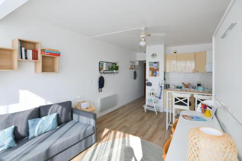 a living room with a couch and a kitchen at Studio Carnon, plage, port et commerces à 2 pas in Carnon-Plage