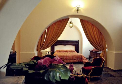 a bedroom with a bed and a couch and a chair at Ai Cartari in Palermo