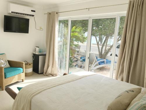a bedroom with a bed and a sliding glass door at Big Room A Spectacular Beach Front View in Savaneta