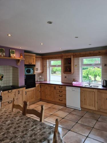 a kitchen with wooden cabinets and white appliances at Contractor Accommodation Antrim in Aldergrove