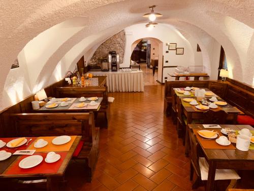 a restaurant with wooden tables with plates on them at Hotel Dolomiti in Malcesine