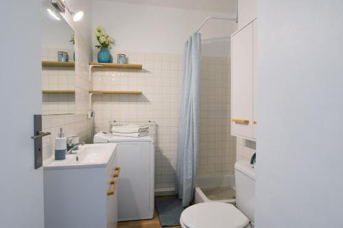 La salle de bains blanche est pourvue de toilettes et d'un lavabo. dans l'établissement Studio Carnon, plage, port et commerces à 2 pas, à Carnon-Plage
