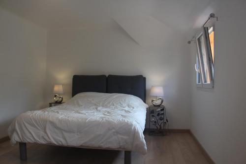 a bedroom with a bed with white sheets and a window at le chemin du meunier in Riquewihr