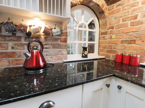 a kitchen with a red tea kettle on a counter at Ash Tree Lodge in Hull
