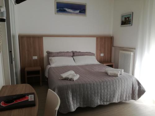 una camera da letto con un letto e due asciugamani di B&b villa lambusta a Cesenatico