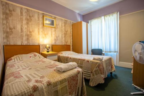 a hotel room with two beds and a window at The Carlton Hotel in Folkestone