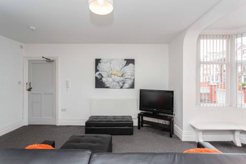 a living room with a couch and a tv at Cherry Property - Orange Suite in Blackpool