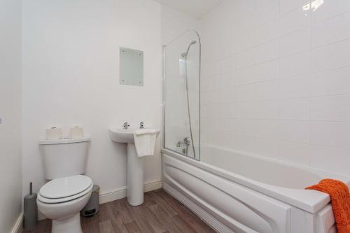 a white bathroom with a toilet and a sink at Cherry Property - Orange Suite in Blackpool