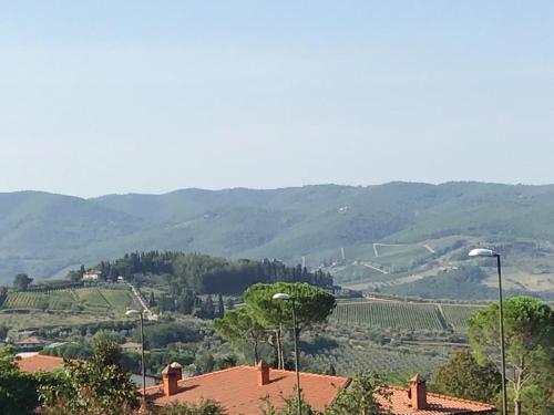 a view of a valley with trees and mountains at La Sosta in Panzano