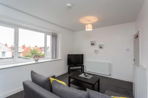 a living room with a couch and a tv at Cherry Property - Pineapple Suite in Blackpool