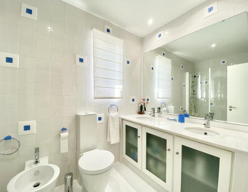 a white bathroom with a toilet and a sink at Sunset Marina - Sea view - Vilamoura in Vilamoura