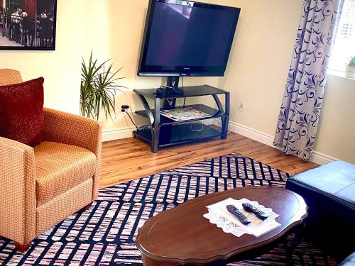 sala de estar con TV y mesa de centro en Elgin Suite, en Niagara Falls